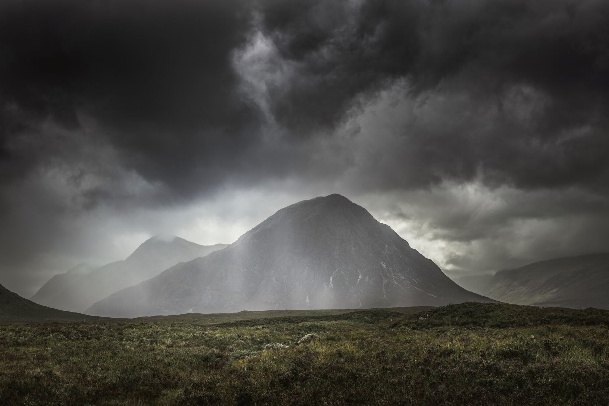 Storm light breaking over a bald mountain summit